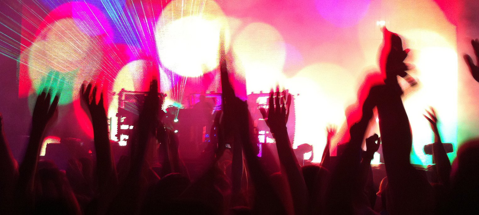 Pink light, party crowd with hands in air
