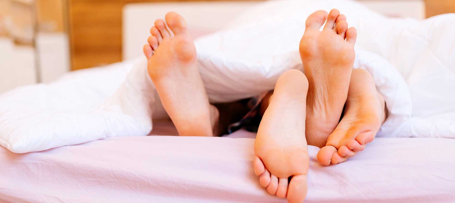 Partners feet out of bed sheets