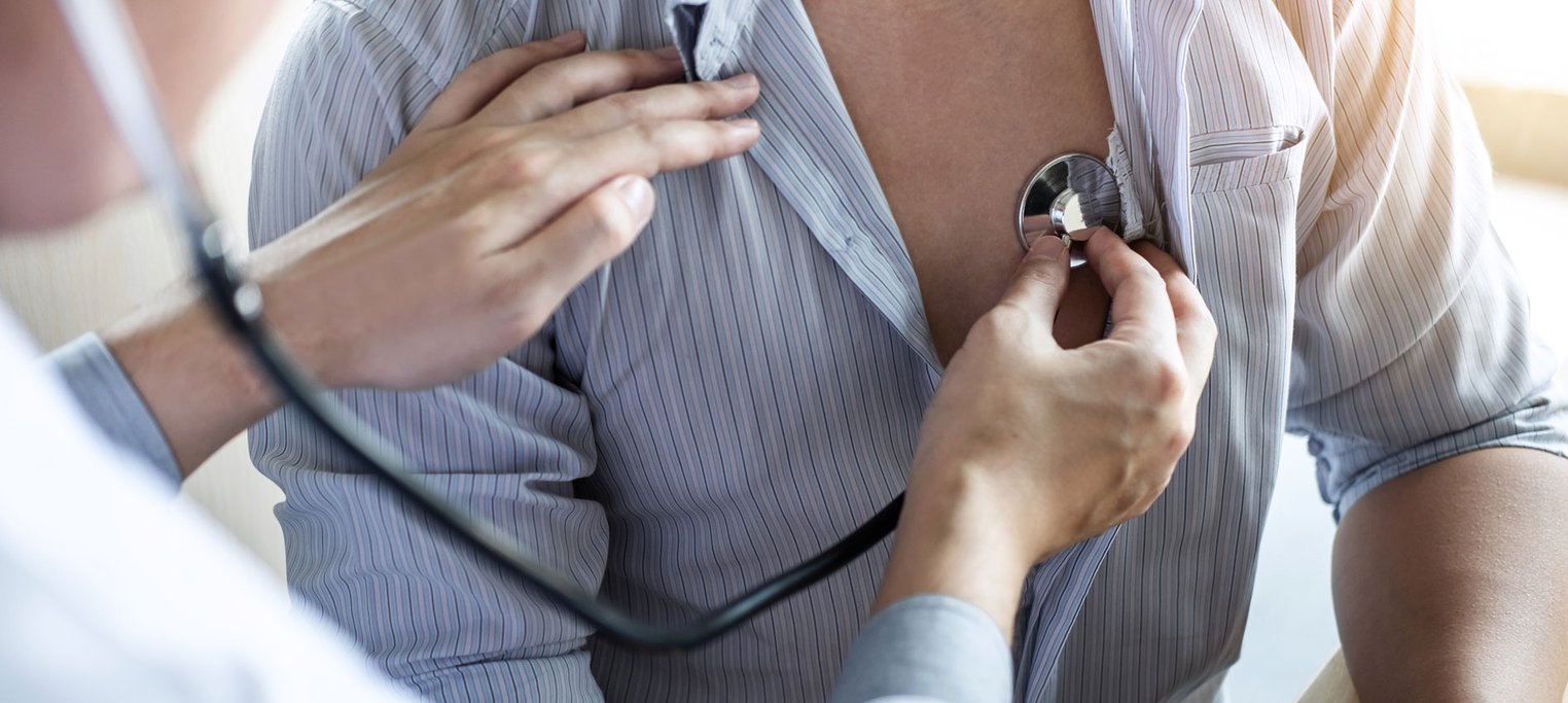 Doctor using stethoscope on patient's chest