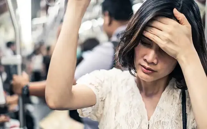 woman on train with headache